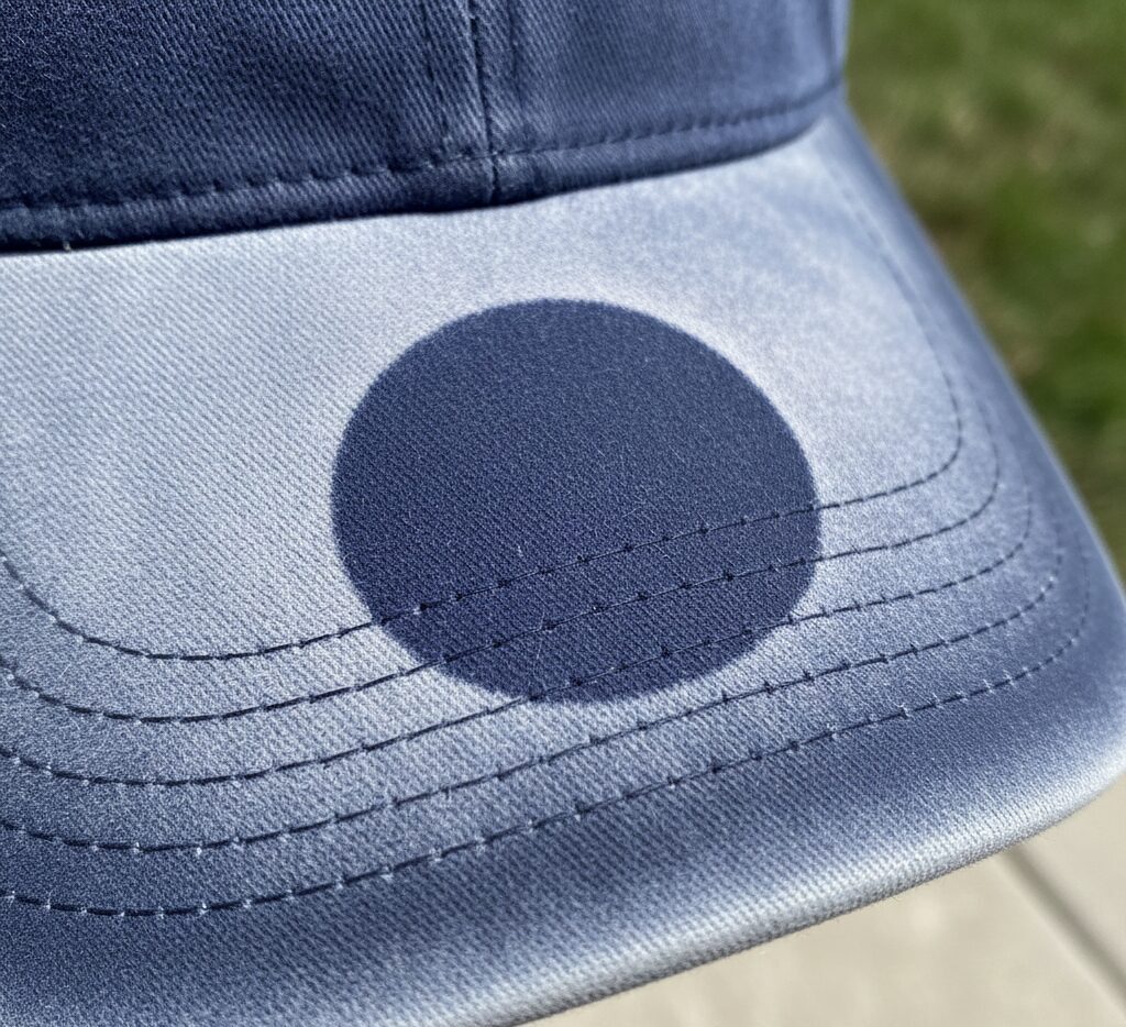 剥がさなかったシール部分だけが濃く残り、周囲が日焼けしてしまったキャップのツバ。色の差によるくっきりとした日焼け跡（ゴースト）。